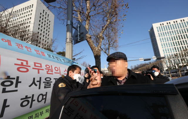 5일 오전 서울 서초구 대검찰청 앞에서 윤석열 검찰총장 응원화환에 불을 붙인 남성이 경찰에 연행되고 있다. /연합뉴스