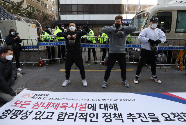 대한민국 기능성 피트니스 협회 관계자들이 5일 서울 영등포구 더불어민주당 당사 앞에서 열린 기자회견에서 모든 실내체육시설에 대해 형평성 있고 합리적인 정책 추진을 촉구하며 크로스핏 동작을 선보이고 있다./연합뉴스