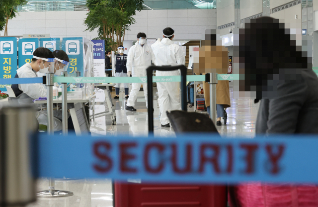 = 30일 오후 인천국제공항 제2여객터미널 입국장에서 일본 오사카발 항공편 해외입국자들이 방역 관계자들의 안내를 받고 있다./연합뉴스