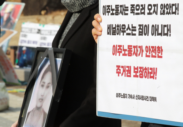 지난해 12월 28일 오후 청와대 분수대 앞에서 열린 ‘이주노동자 비닐하우스 숙소 산재사망 진상 규명 및 대책 마련 촉구 기자회견’에서 참석자들이 대책 마련을 촉구하는 손팻말을 들고 있다.   /연합뉴스