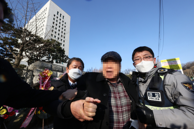 지난 5일 오전 서울 서초구 대검찰청 앞에서 윤석열 검찰총장 응원화환에 불을 붙인 남성이 경찰에 연행되고 있다./연합뉴스