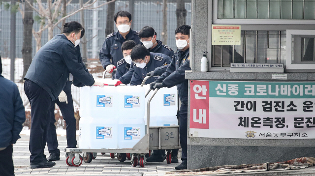 동부구치소의 수용자들과 직원에 대한 신종 코로나바이러스 감염증(코로나19) 8차 전수조사가 진행중인 11일 오후 서울 송파구 동부구치소에서 관계자들이 소독제를 옮기고 있다./연합뉴스