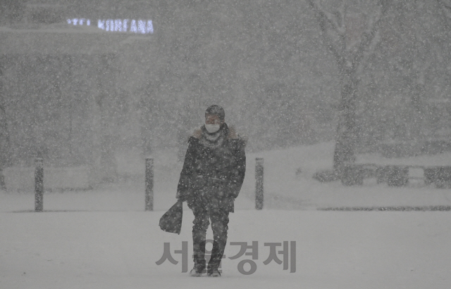 서울 일부 지역을 비롯한 전국 곳곳에 대설 특보가 내려진 12일 오후 많은 눈이 내리는 서울 종로구 세종대로에서 시민들이 퇴근길 발걸음을 재촉하고 있다./오승현기자 2021.01.12