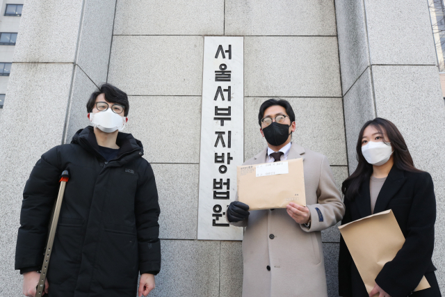 12일 오전 서울 마포구 서울서부지방법원 앞에서 열린 '필라테스 피트니스사업자연맹 정부 상대 집단 소송 기자회견'에서 박주형 필라테스 피트니스사업자연맹 대표(왼쪽)가 소송 대리인들과 함께 소장을 들고 있다./연합뉴스