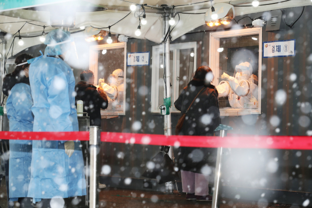 눈이 내린 12일 오후 서울역 광장에 마련된 코로나19 임시 선별검사소에서 시민들이 검사를 받고 있다. /연합뉴스