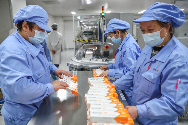 중국 베이징에 있는 제약회사 시노백의 신종 코로나바이러스 감염증(코로나19) 백신 패키징 시설에서 6일 직원들이 업무를 처리하고 있다./연합뉴스
