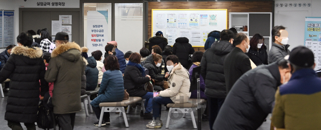 코로나19 사태로 지난해 취업자가 1년 전보다 22만 명 가까이 줄어 1998년 외환위기(IMF) 이후 가장 큰 폭으로 감소하고, 실업자가 19년 만에 최고치인 111만 명에 육박하는 등 고용시장이 꽁꽁 얼어붙었다. 통계청이 '2020년 연간 고용동향'을 발표한 13일 오전 서울 마포구 서울서부고용센터를 찾은 실업급여 수급 대상자들이 줄지어 실업급여 설명회장 입장을 기다리고 있다./오승현기자 2021.01.13