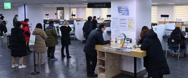 코로나19 사태로 지난해 취업자가 1년 전보다 22만 명 가까이 줄어 1998년 외환위기(IMF) 이후 가장 큰 폭으로 감소하고, 실업자가 19년 만에 최고치인 111만 명에 육박하는 등 고용시장이 꽁꽁 얼어붙었다. 통계청이 '2020년 연간 고용동향'을 발표한 13일 오전 서울 마포구 서울서부고용센터를 찾은 실업급여 수급 대상자들이 실업급여 지급을 신청하고 있다./오승현기자 2021.01.13