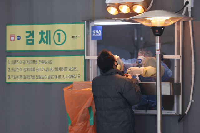 지난 13일 서울시청 앞 마련된 임시선별진료소에서 의료진이 검체채취를 하고 있다./연합뉴스