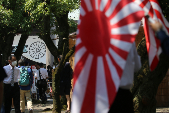 지난 해 8월 15일 일본 도쿄 야스쿠니신사에서 욱일기를 소지한 이들이 참배를 위해 대기 중이다./연합뉴스