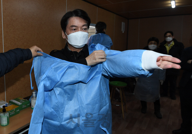 안철수 국민의당 대표가 15일 오전 서울광장에 마련된 임시 선별검사소에서 검체를 채취하는 의료자원봉사에 앞서 방호복으로 환복하고 있다./국회사진기자단 2021.01.15