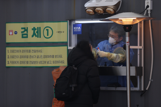 15일 서울시청 앞에 마련된 임시선별진료소에서 의료진이 검체 채취를 하고 있다./연합뉴스