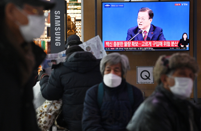 18일 오전 서울역에서 시민들이 문재인 대통령의 신년 기자회견을 시청하고 있다./오승현기자 2021.01.18