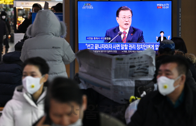 18일 오전 서울역에서 시민들이 문재인 대통령의 신년 기자회견을 시청하고 있다./오승현기자 2021.01.18