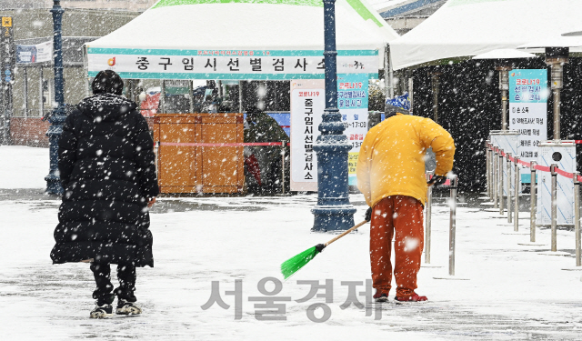 18일 오전 서울역 광장에 마련된 코로나19 임시 선별검사소에서 관계자가 눈을 쓸고 있다. 이날 출근 시간대에 폭설이 내릴 것으로 예보됐었으나, 눈이 내리지 않아 우려했던 출근길 교통대란은 발생하지 않았다./오승현기자 2021.01.18