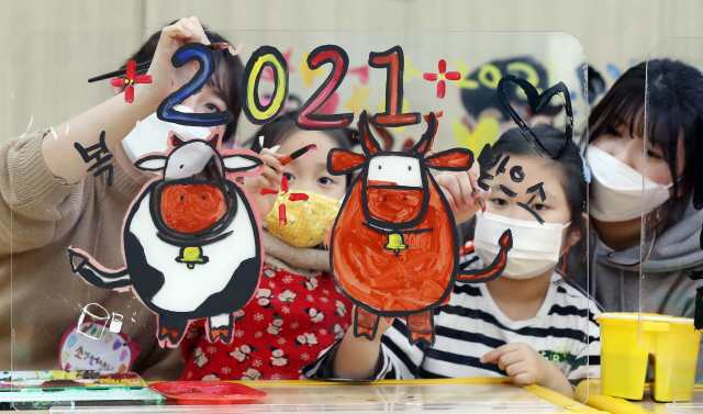 6일 오후 광주 북구청직장어린이집에서 신축년 새해를 맞아 어린이들이 선생님들과 함께 투명 아크릴판에 소를 그리고 색칠하는 놀이를 하고 있다./연합뉴스