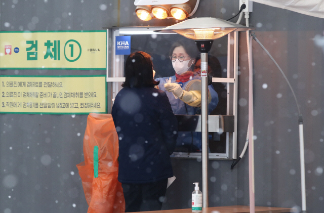 지난 18일 오전 서울광장에 마련된 코로나19 임시 선별검사소에서 의료진이 검체 채취를 하고 있다./연합뉴스
