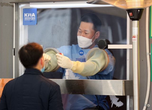 19일 오후 서울광장에 마련된 임시 선별진료소에서 의료진이 검체를 채취하고 있다. /연합뉴스