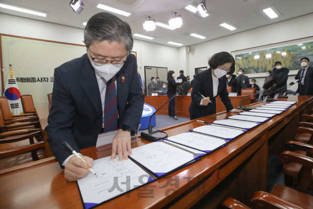 변창흠 국토교통부 장관, 조성욱 공정거래위원장이 21일 오전 서울 여의도 국회에서 열린 더불어민주당 민생연석회의 택배종사자 과로대책 사회적 합의기구 1차 합의문 발표식에서 합의문에 서명하고 있다./권욱기자 2021.01.21.