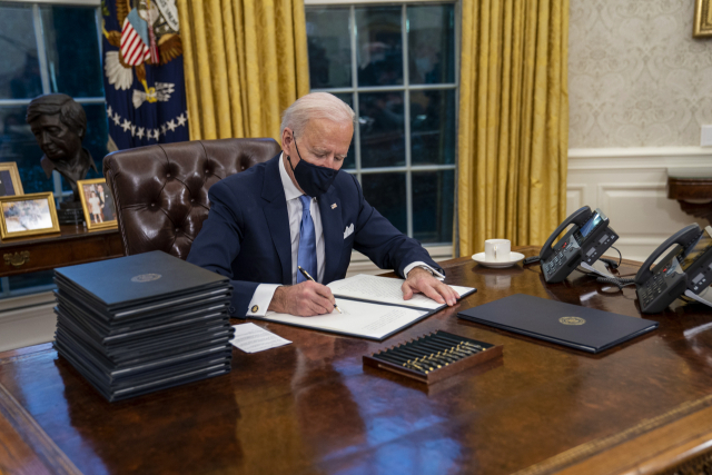조 바이든 미국 대통령이 20일(현지시간) 워싱턴DC 백악관 내 집무실에서 각종 행정명령에 서명하고 있다. /연합뉴스