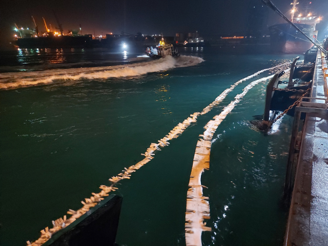 해경이 22일 오전 울산 앞바다에서 기름을 유출한 선박 주변으로 오일펜스를 설치하고 기름 회수 작업을 벌이고 있다. /사진제공=울산해양경찰서