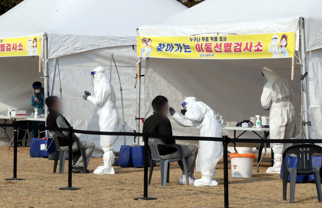 서부산단 근로자 대상으로 찾아가는 이동 선별검사소가 설치된 부산 강서구 녹산국가산업단지 내 희망공원에서 의료진들이 18일 코로나19 진단검사를 위한 검체채취를 하고 있다./연합뉴스