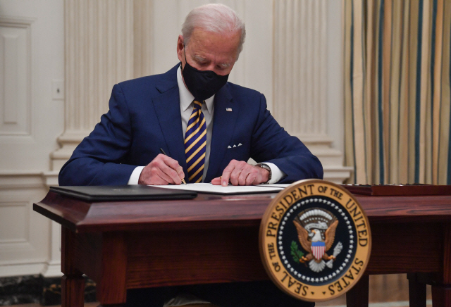 조 바이든 미국 대토령이 지난 22일(현지시간) 백악관에서 코로나19 경제 구제 행정명령에 서명하고 있다. /AFP연합뉴스