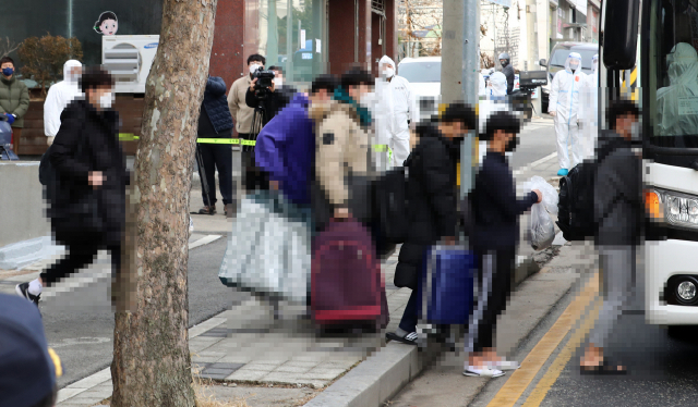 25일 오전 대전시 중구 대흥동 IEM국제학교 코로나19 확진자들이 충남 아산 생활치료센터로 이동하기 위해 차량에 탑승하고 있다. /연합뉴스