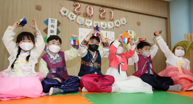 설날 연휴가 보름여 앞으로 다가온 가운데 26일 광주시 북구청 직장어린이집 아이들이 설 맞이 선물로 복주머니를 받은 뒤 활짝 웃고 있다. /광주=연합뉴스