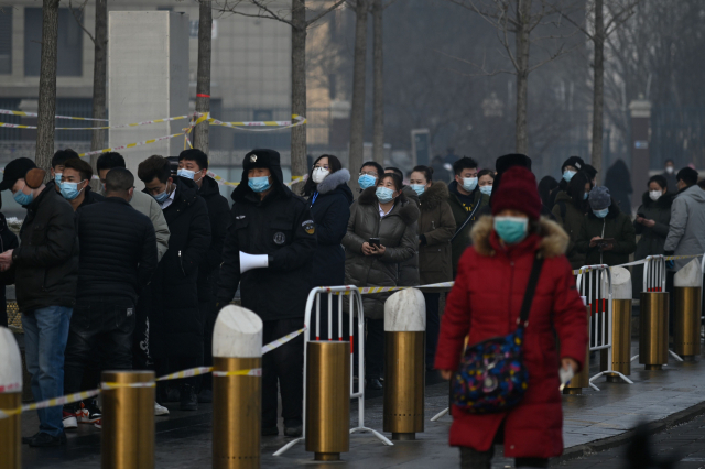 중국 베이징의 한 거리에 26일(현지시간) 코로나19 검사를 받으려는 사람들이 줄을 서 있다. /AFP연합뉴스