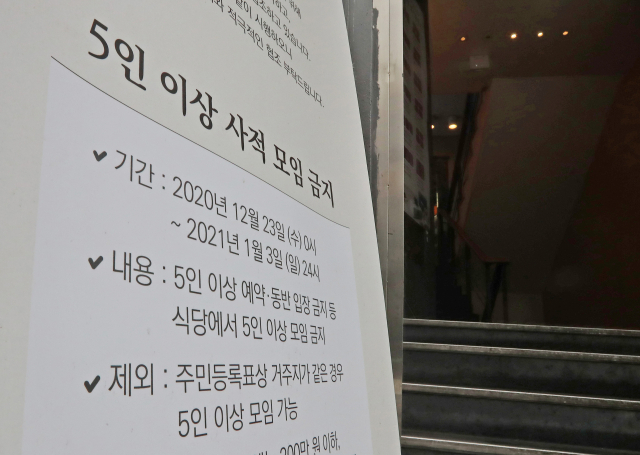 지난 18일 오후 서울 마포구 한 식당에 5인 이상 모임 금지조치와 관련된 안내문이 게시돼있다./연합뉴스