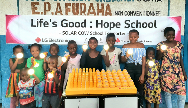 콩고민주공화국 프라하 초등학교 학생들이 LG전자가 설치한 친환경 태양광 충전 시스템을 이용해 충전한 휴대용 보조 배터리를 들고 기념 촬영을 하고 있다. /사진 제공=LG전자