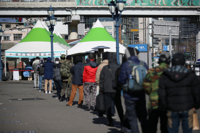 지난 29일 서울역광장에 설치된 임시선별진료소에서 시민들이 코로나19 검사를 받기 위해 줄을 서고 있다./연합뉴스