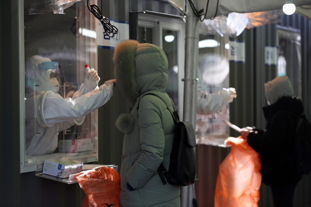 지난 29일 오후 서울역광장에 설치된 임시선별진료소에서 의료진이 검체채취를 하고 있다./연합뉴스