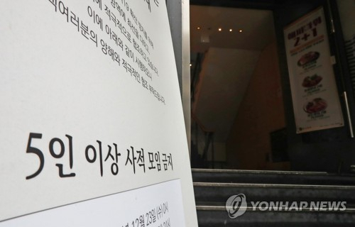 지난 18일 오후 서울 마포구 한 식당에 5인 이상 모임 금지조치와 관련된 안내문이 게시돼있다./연합뉴스