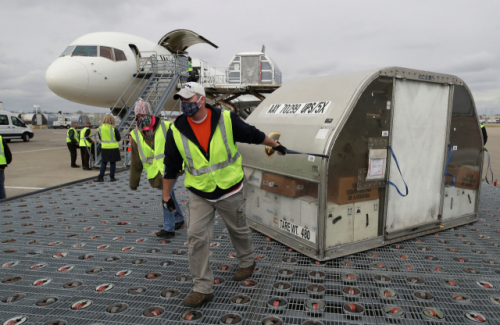 미국 UPS 직원들이 켄터키주 루이스빌 무함마드 알리 국제 공항에서 화이자의 코로나19 백신을 실은 컨테이너를 옮기고 있다./로이터연합뉴스