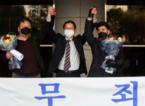 경찰 고문과 가혹행위로 인해 살인죄 누명을 쓴 채 21년간 억울한 옥살이를 한 '낙동강변 살인사건' 피해 당사자 최인철(왼쪽)씨와 장동익씨, 박준영 변호사(가운데)가 4일 오전 부산고등법원에서 열린 재심 선고 공판을 마치고 손을 맞잡고 있다. 부산고법 제1형사부는 이날 재심청구 선고 재판에서 두 사람에게 무죄를 선고했다./연합뉴스