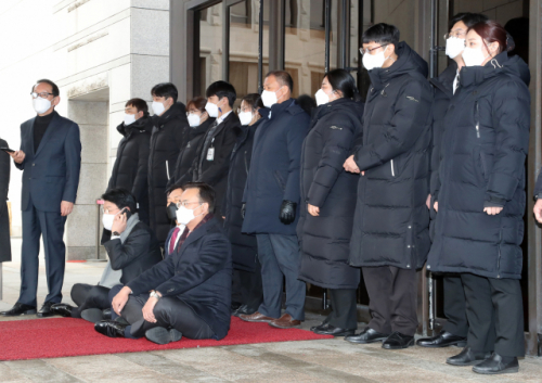 국민의힘 탄핵거래 진상조사단 소속 의원들이 5일 오전 서울 서초구 대법원을 항의 방문, 정식 허가 절차를 요구하는 보안 직원들에게 출입을 제지당하자 바닥에 앉아 항의하고 있다. /연합뉴스