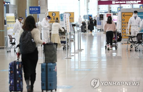 6일 인천국제공항 1터미널 입국장에서 방역 관계자들이 해외입국자들에게 식별 스티커를 부착해주고 있다. /연합뉴스