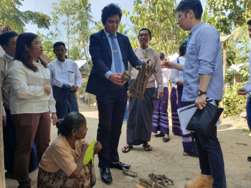 유웅환 SK텔레콤 ESG그룹장(부사장)이 미얀마 주민들에게 쿡스토브를 지원하며 나무 땔감을 들어보이고 있다.