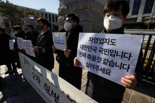 4일 오전 서울 종로구 헌법재판소 앞에서 열린 '금지'만 있고 '보상'은 없는 집합금지조치 2차 헌법소원심판 청구 기자회견에서 대한당구장협회, 대한피트니스경영자협회 등 참석자들이 관련 내용이 적힌 손 피켓을 들고 있다. /연합뉴스