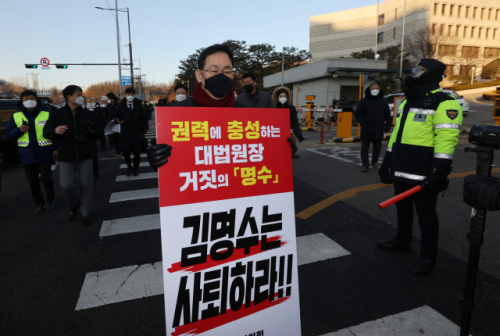 주호영 국민의힘 원내대표가 8일 오전 서울 서초구 대법원 앞에서 김명수 대법원장의 사퇴를 촉구하는 피켓을 들고 1인 시위를 하기 위해 이동하고 있다. /연합뉴스