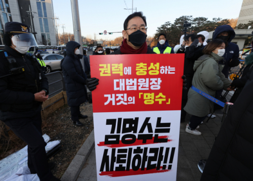 주호영 국민의힘 원내대표가 8일 오전 서울 서초구 대법원 앞에서 김명수 대법원장의 사퇴를 촉구하는 피켓을 들고 1인 시위를 하기 위해 이동하고 있다. /연합뉴스