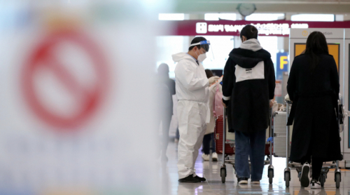 8일 오후 인천국제공항 제1터미널 입국장에서 방역관계자들이 해외입국자에게 식별스티커를 붙여 주고 있다. /연합뉴스
