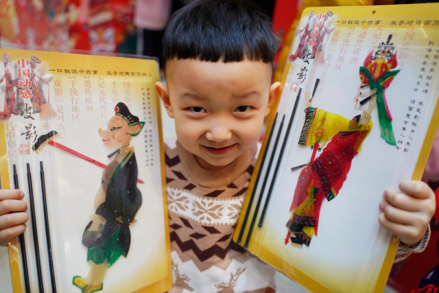 중국 허베이성의 한 아이가 춘제(중국의 설날)을 며칠 앞둔 8일 전통 그림자 인형극 놀이 세트를 받고 기뻐하고 있다. /신화연합뉴스