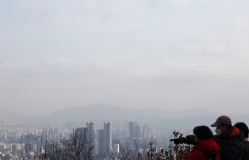 포근하지만 서쪽 지역을 중심으로 미세먼지가 발생한 지난달 31일 오후 서울 남산을 찾은 시민이 마스크를 쓴 채 시내를 바라보고 있다. /연합뉴스