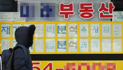 서울 용산구의 한 공인중개사무소 앞을 한 시민이 지나가고 있다. /오승현기자