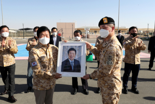 박병석(왼쪽) 국회의장이 12일(현지시각) 아부다비 인근 UAE 군사훈련협력단(아크부대)을 방문해 자신의 얼굴을 부대 훈련사진으로 모자이크한 사진을 전달받고 있다. /연합뉴스