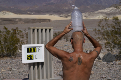 지난 2020년 8월 미국 캘리포니아주 데쓰밸리 국립공원에서 한 남성이 머리에 얼음 물통을 올린 채 온도계를 바라보고 있다./AP연합뉴스