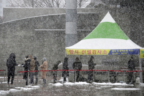 17일 광주 서구 시청광장에 설치된 신종 코로나바이러스 감염증(코로나19) 임시 선별검사소에서 시민들이 눈을 맞으며 줄 서 있다./연합뉴스